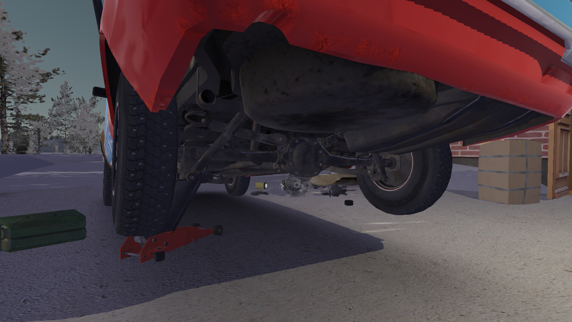 The underside of a red car raised on a jack outside a garage in My Winter Car